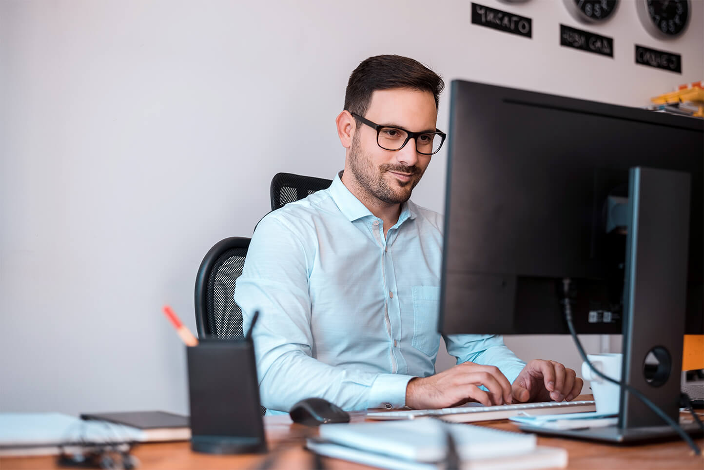 delighted-programmer-with-glasses-using-computer